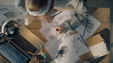 artist working on sketches at a desk