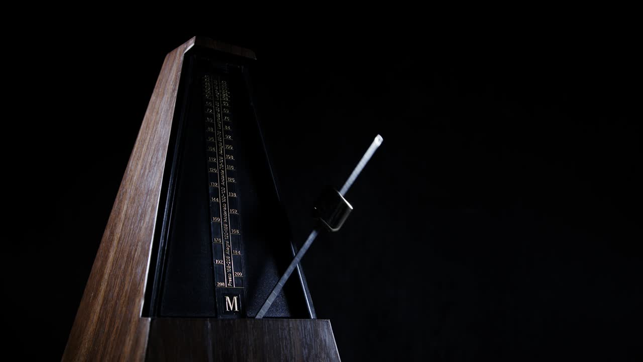 황금색 진동기를 가진 메트로은 어두운 배경에서 느린 리을 치고 있습니다.