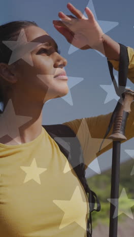 animación de la bandera estadounidense sobre una mujer biracial mirando hacia las montañas