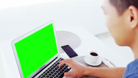 hombre usando computadora portátil con café