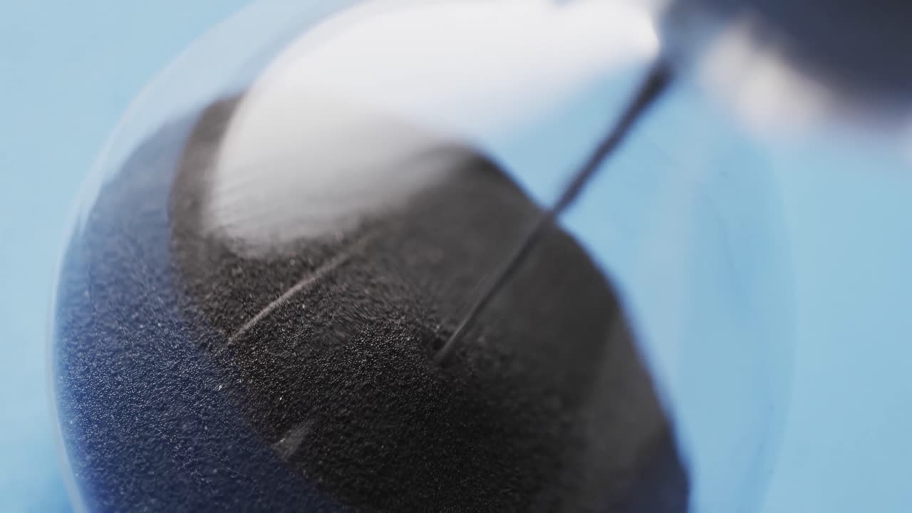 파란색 배경에 복사 공간과 함께 흘러내리는 검은 모래와 함께 모래시계의 클로즈업 비디오