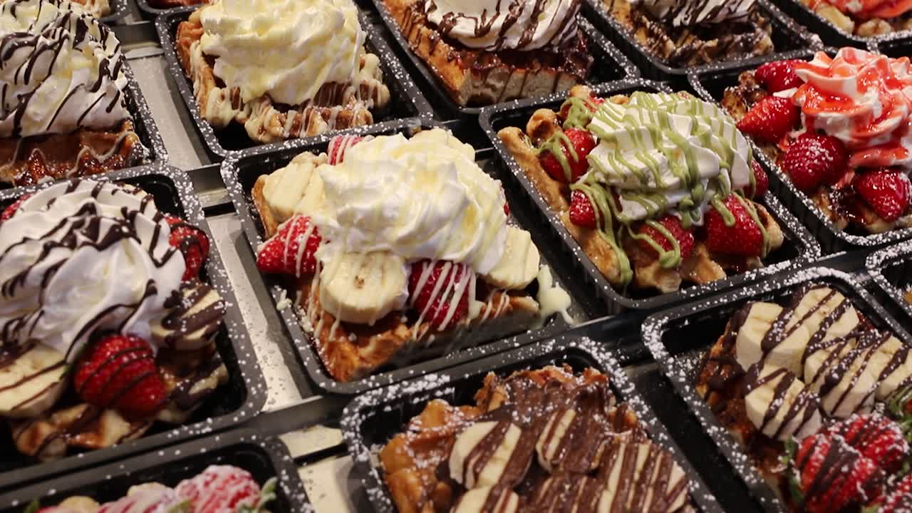 Delicious display of freshly made Belgian waffles topped with cream, bananas, strawberries, and chocolate in Brussels