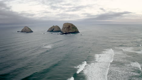 scenic view of sea stacks and ocean waves under a cloudy sky