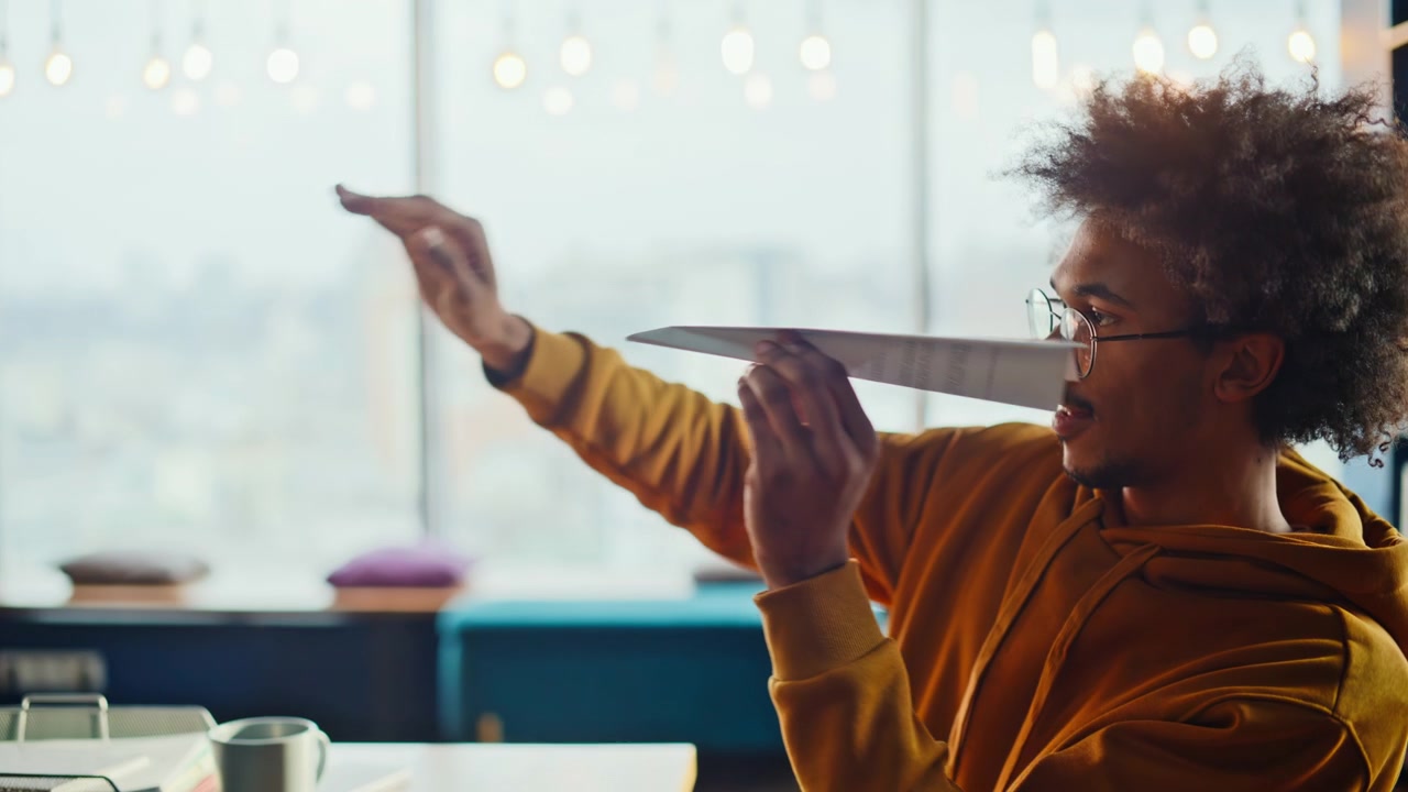 Man folding paper plane throwing colleague. Fun office break coworking prank.