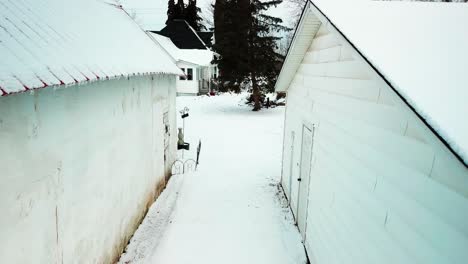 slow aerial shot between two barns to reveal 19th century farmhouse in the winter. 4k