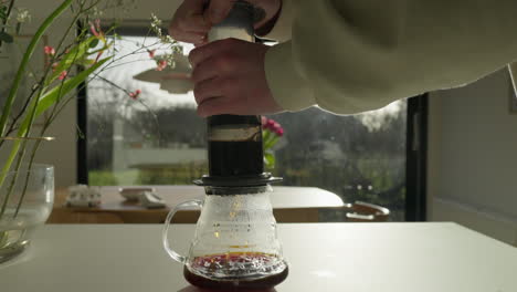 preparación de café por la mañana con una prensa en una cocina empapada de sol