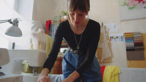 female dressmaker drawing on fabric with chalk