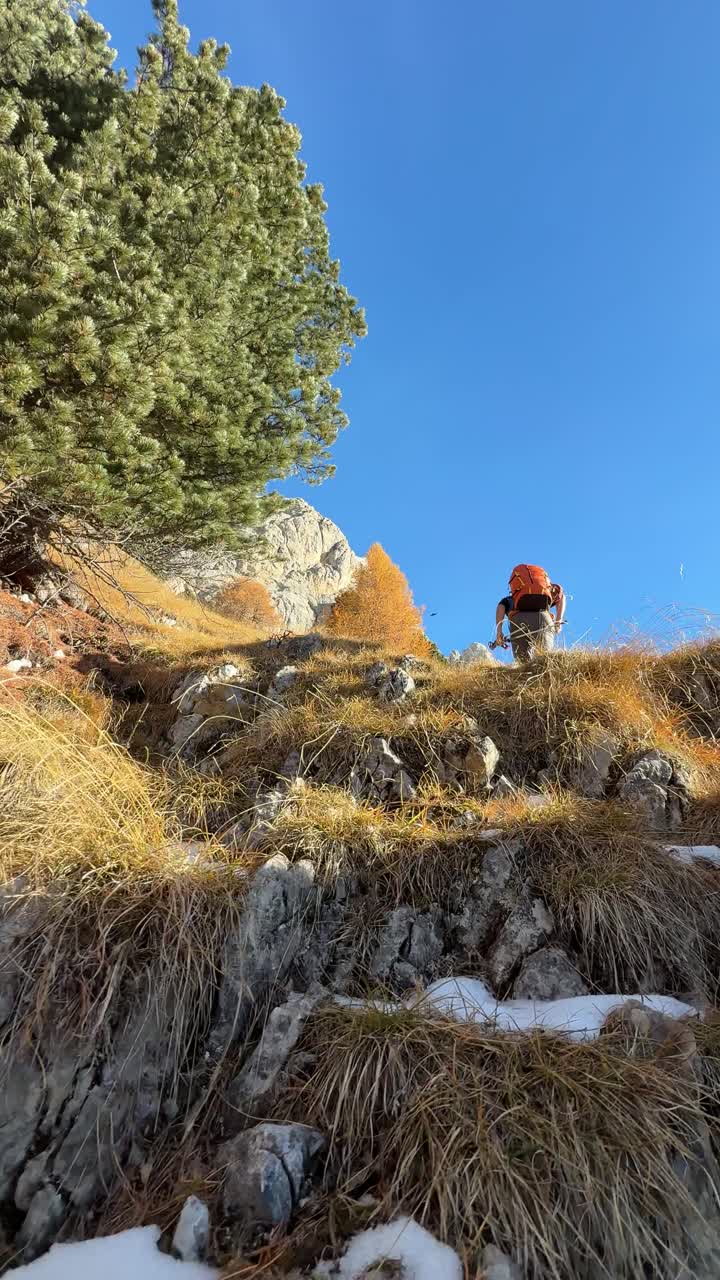 Un escursionista scala il ripido pendio alpino in Val di Fassa, Trentino, Italia - Scatto verticale.