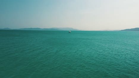 Cinematic-aerial-approach-on-a-sailboat-above-a-beautiful-sea