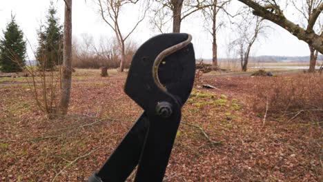 Close-up-of-black-garden-shears-lopper-open-and-close-with-garden-background