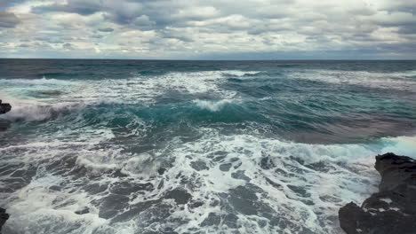 a close-up view of waves crashing against the rocky shore in cyprus