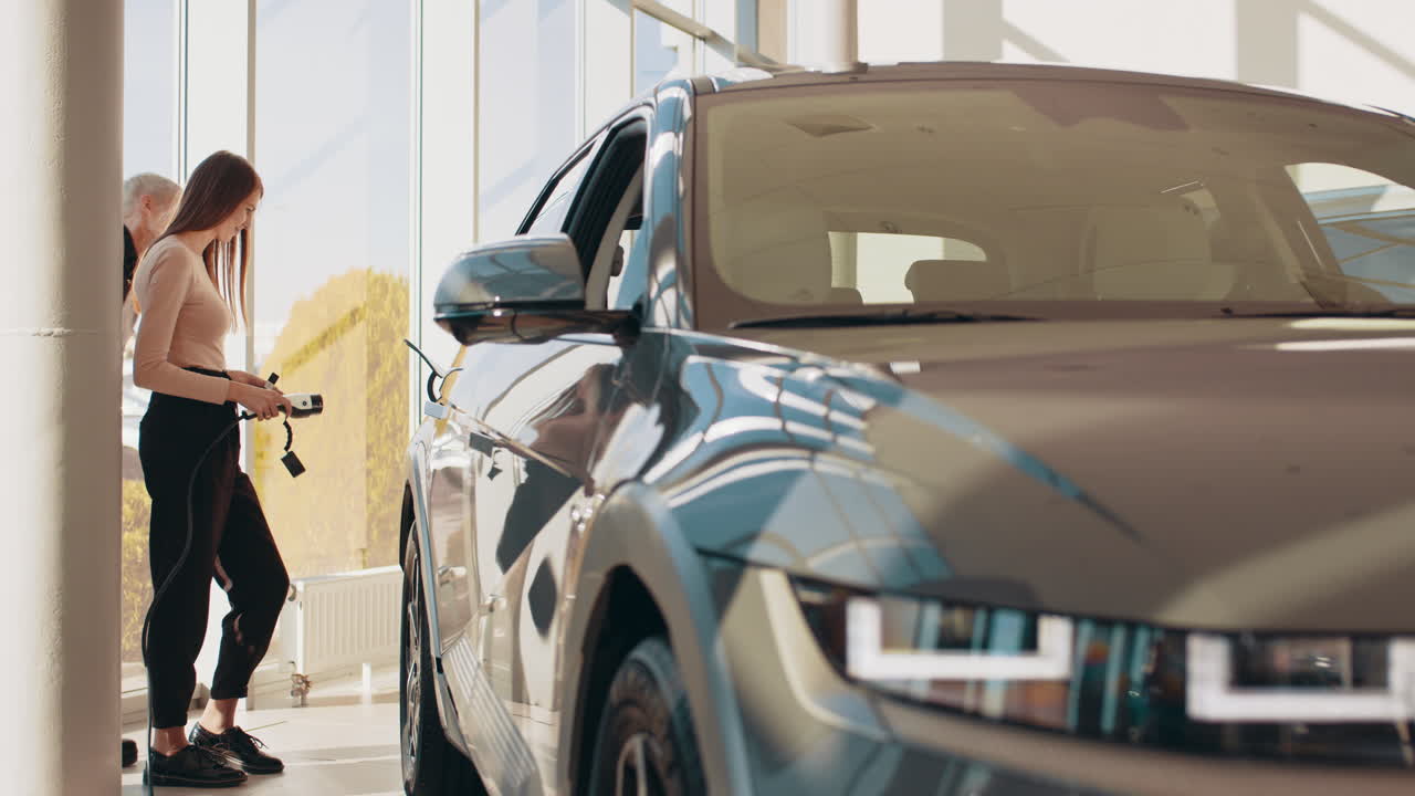 mujeres viendo un vehículo eléctrico en una sala de exposiciones
