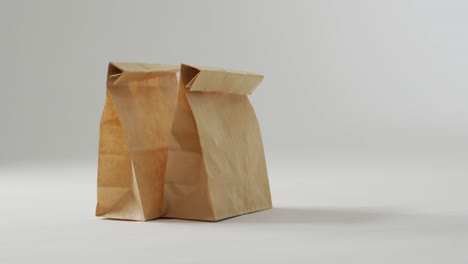 animation of paper lunch bags on white background