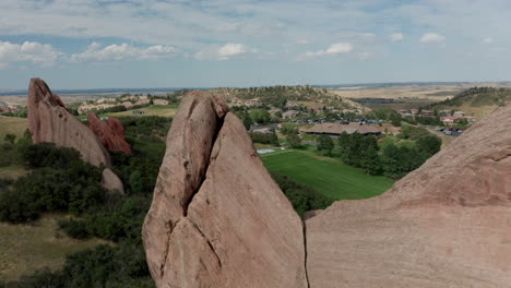 campo de golf de punta de flecha en littleton colorado con césped verde, rocas rojas y cielos azules