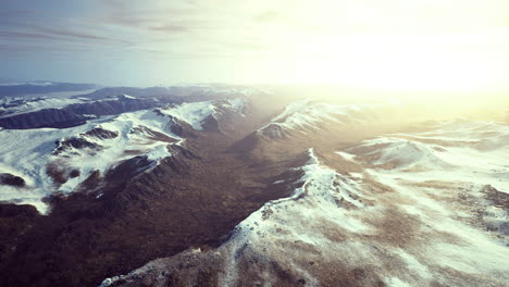 vast snowy mountain range illuminated by golden sunlight at dawn