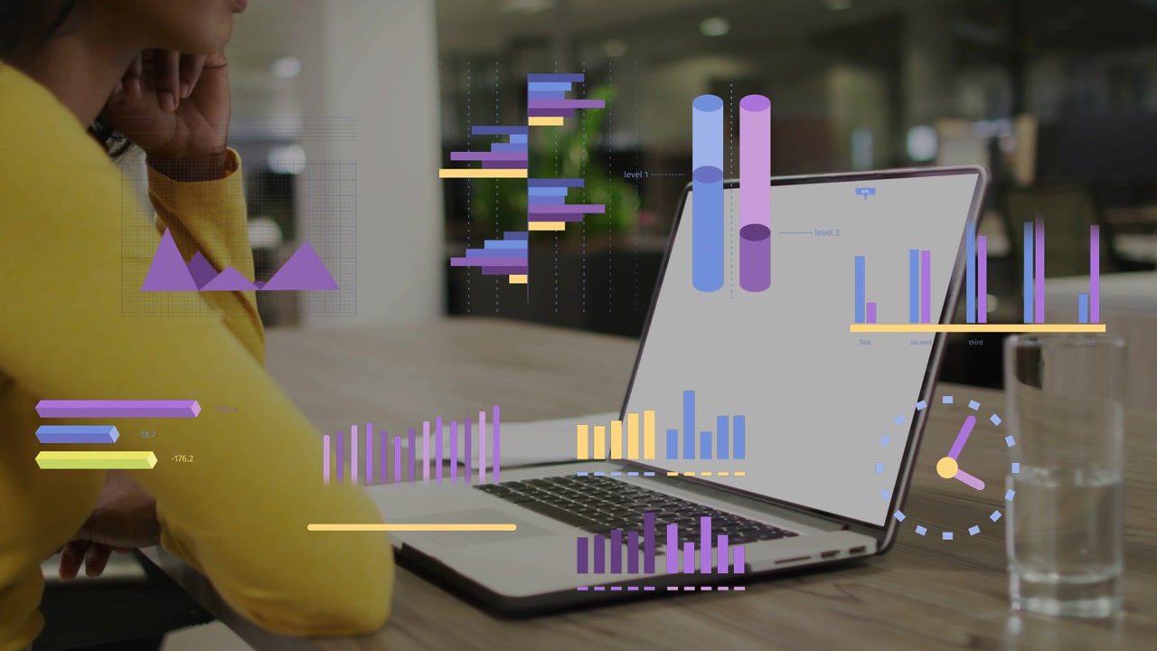 Woman sitting at table monitoring laptop while business feed triggers waveform and bars over laptop