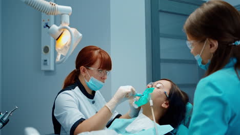 Girl having dental treatment. Woman having dental procedure at the dentistry clinic