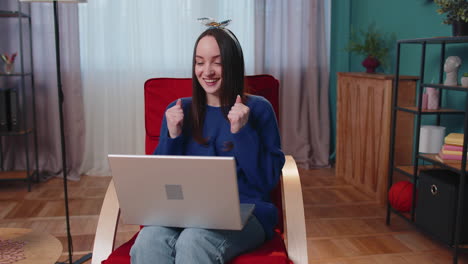 mujer adulta joven en la oficina de casa usar computadora portátil computadora mecanografiando navegación decir wow sí descubrió gran gran victoria
