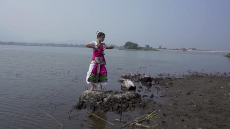 A-bharatnatyam-dancer-displaying-a-classical-bharatnatyam-pose-in-the-nature-of-Vadatalav-lake,-Pavagadh