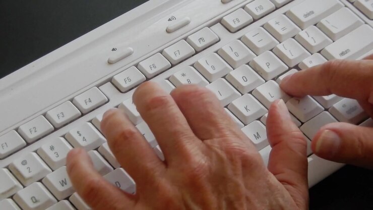 Person's hand diligently typing on a computer keyboard .
