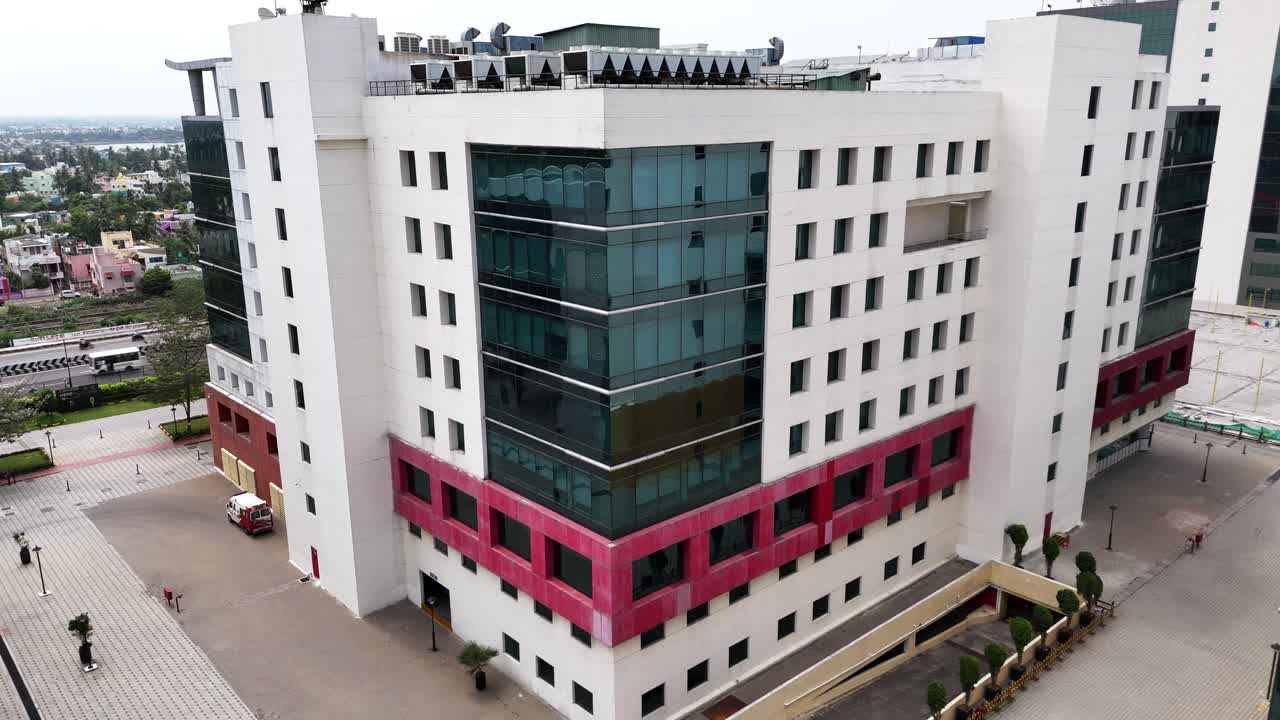 Sleek Business Housing: Elevated view of a densely built modern commercial area. The architecture mixes geometric white panels and large glass curtain walls