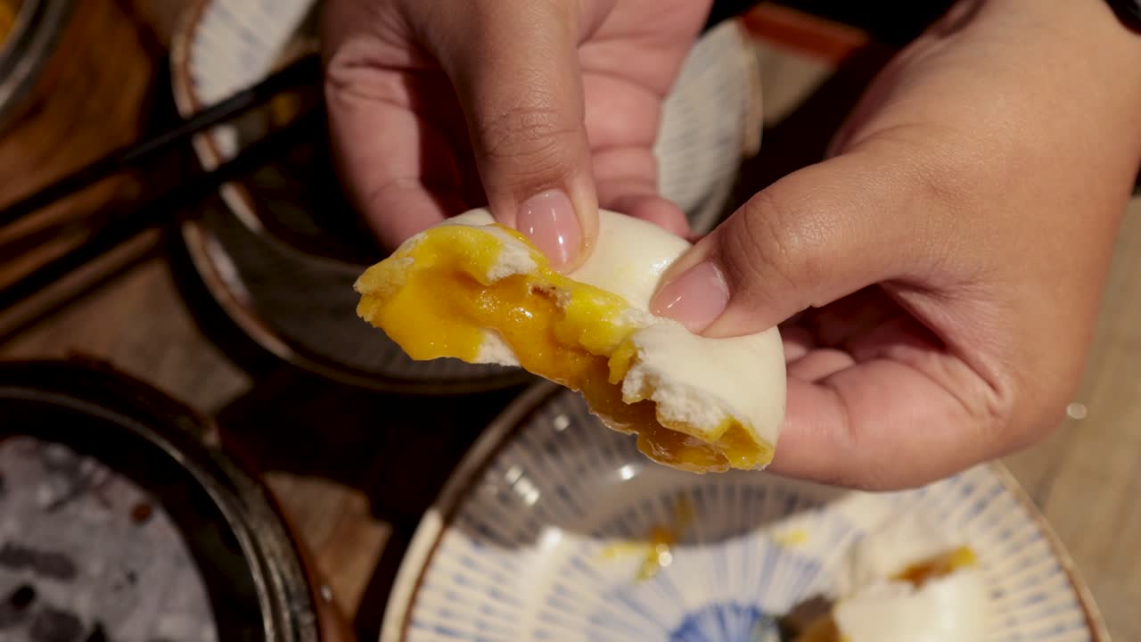 las manos revelan el relleno de pan al vapor