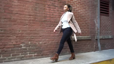 Black-model-walks-down-an-alleyway-near-a-brick-wall-2