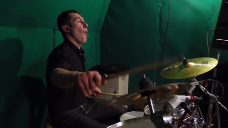 drummer playing drums in a studio with green screen