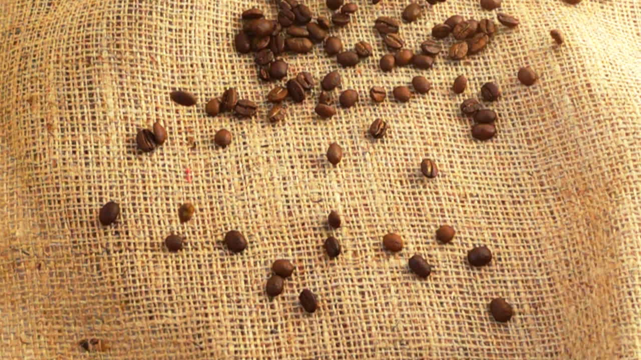 Grãos de café caindo sobre estopa. Câmera lenta.