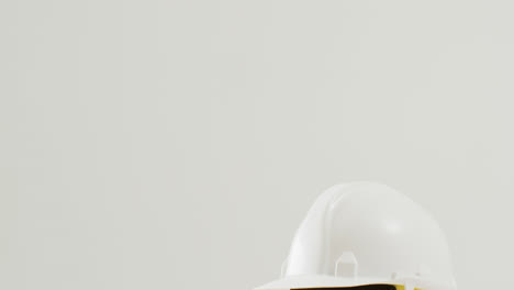 video de primer plano de coloridos cascos de construcción sobre un fondo blanco