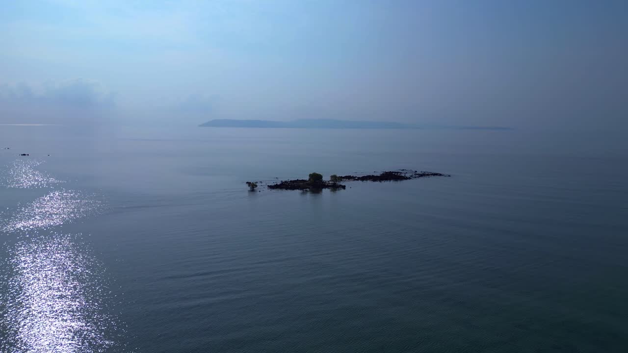 small island emerging from the shallow water with mangrove trees growing on rocks. Great aerial view flight fly push forward drone