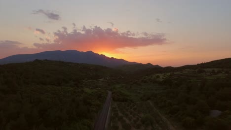 aerial: a car driving during sunset in the mountains of the greek island samos