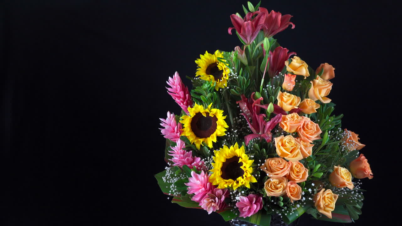 Composizione floreale con girasoli, rose e gigli, scorrimento panoramico su sfondo nero
