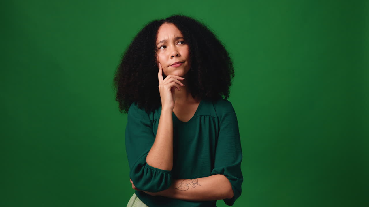 Portrait of a Smiling Woman with Curly Hair in Front of a Green Screen