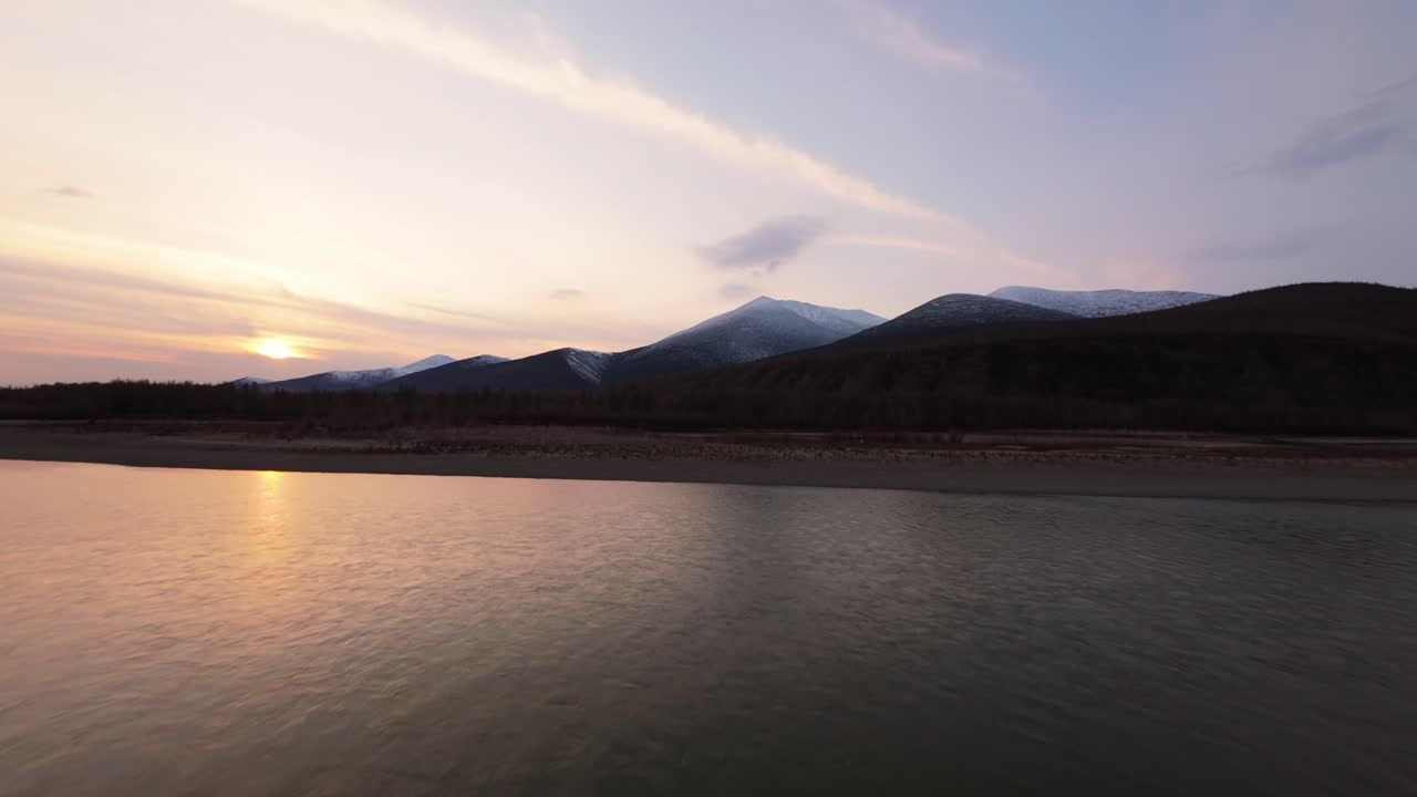 황금빛의 빛이 높은 산과 조용한 물을 는 놀라운 항공 탐사를 목격하십시오.