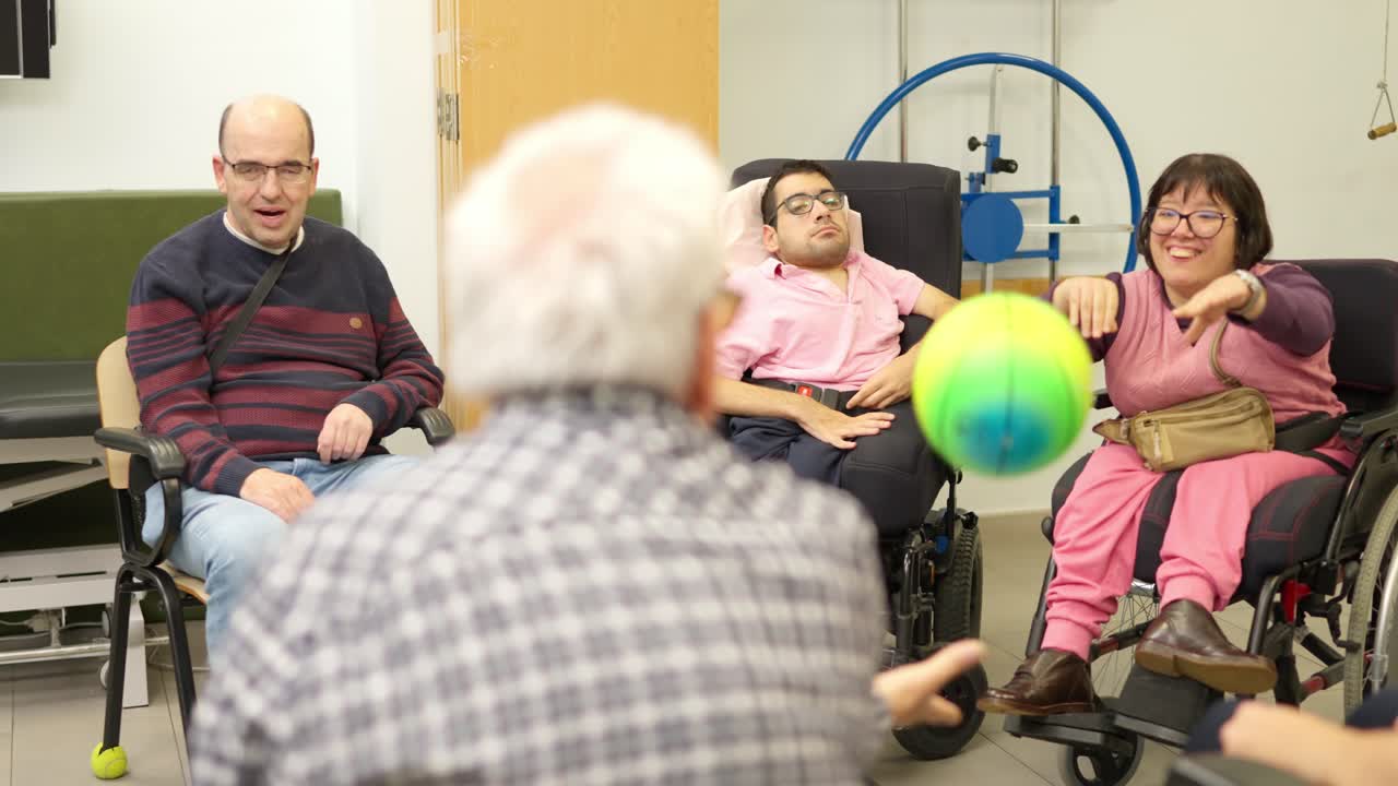 Gruppo eterogeneo di adulti con disabilità che giocano a palla durante una sessione di terapia