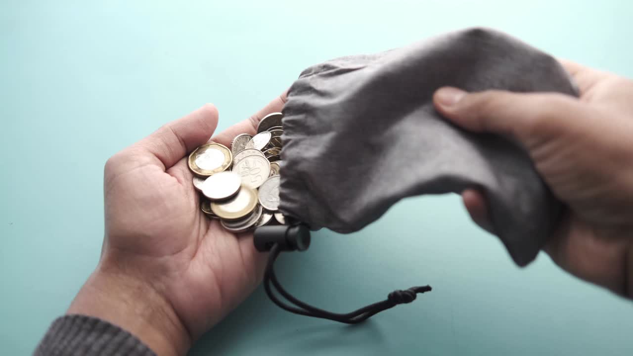 cerca de las monedas que se derraman de una bolsa pequeña