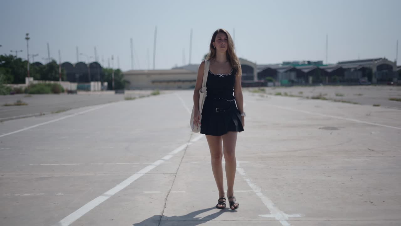 Woman walking on an empty industrial road