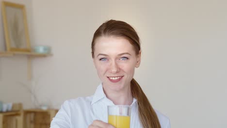 una mujer bebiendo jugo de naranja.