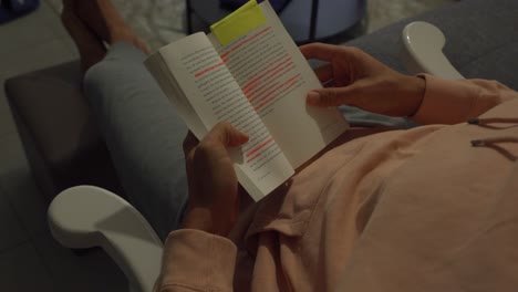 hombre sentado en su mecedora y leyendo un libro con texto resaltado
