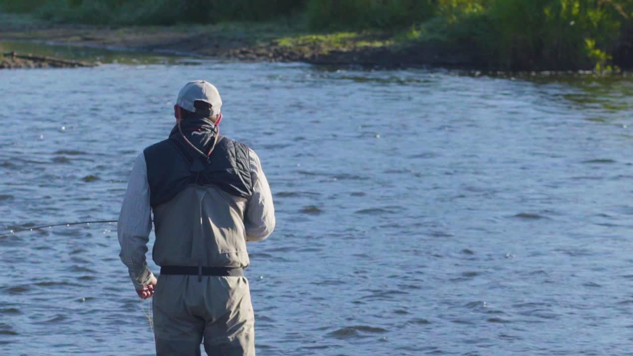 primer plano de un pescador con mosca con excelente técnica trabajando su caña y carrete 1