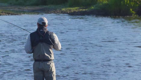 primer plano de un pescador con mosca con excelente técnica trabajando su caña y carrete 1