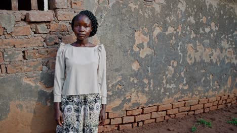 young woman in front of a brick wall in rural africa