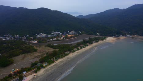 toma de drones de una playa pública con montañas y bosques alrededor durante el día