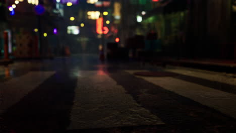 a nighttime view of a wet crosswalk in a city