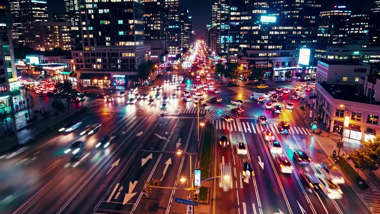 Vista aerea di un vivace incrocio cittadino di notte, che mostra scie luminose vibranti dal traffico.