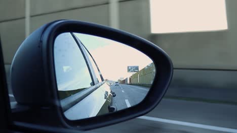 view of passenger side view mirror while driving on highway