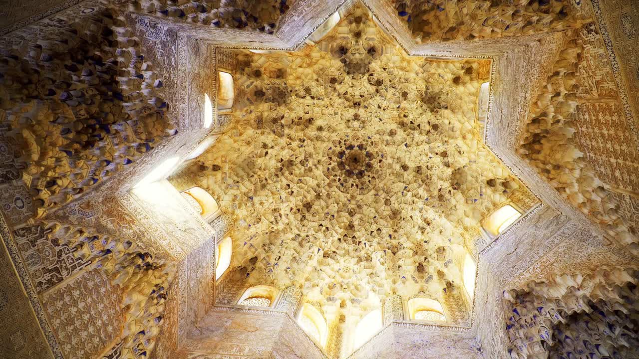 vista hacia arriba de un techo tallado en forma de estrella de 8 puntas en el palacio de la alhambra, españa