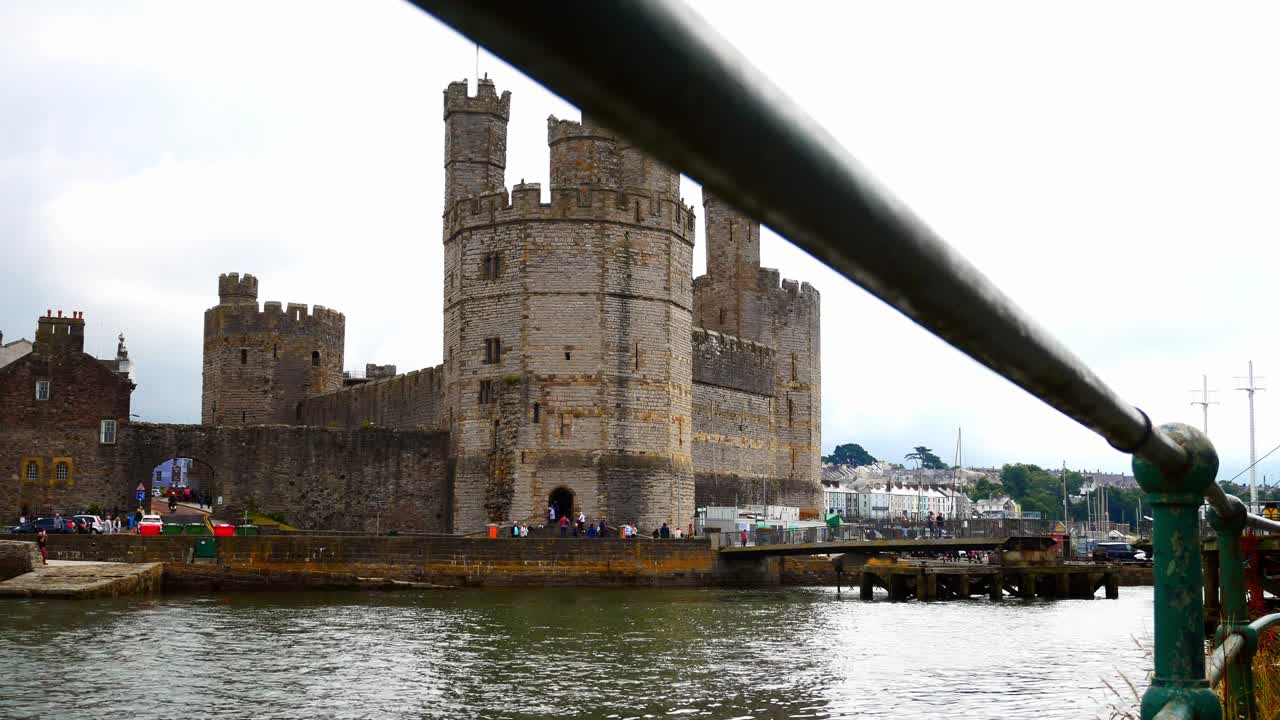 histórico castillo de caernarfon puerto medieval galés ciudad costera histórica dolly izquierda a través de barandillas