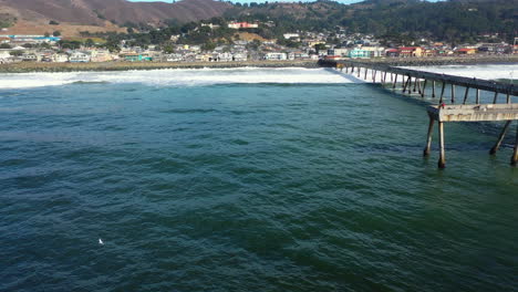 aerial view over waves, around the pacifica municipal pier in california, usa